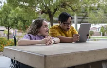 Friends with disabilities looking at an iPad together