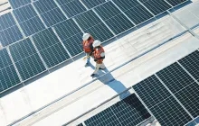 Workers on a roof with solar panels