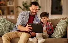 Father and son looking at iPad together