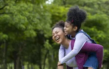 Mother and daughter laughing outside