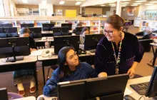 Teacher helping student in computer lab