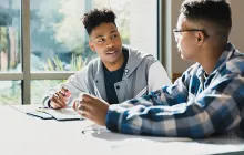 Two high school students talking in library