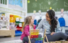 Young special education student with teacher in classroom
