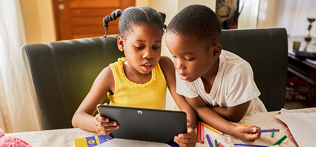Image of young boy and girl looking at a tablet together