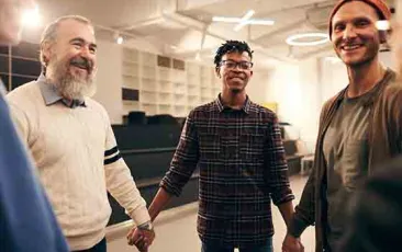 Men holding hands in a support group