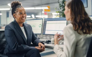 Female colleagues chatting at desk
